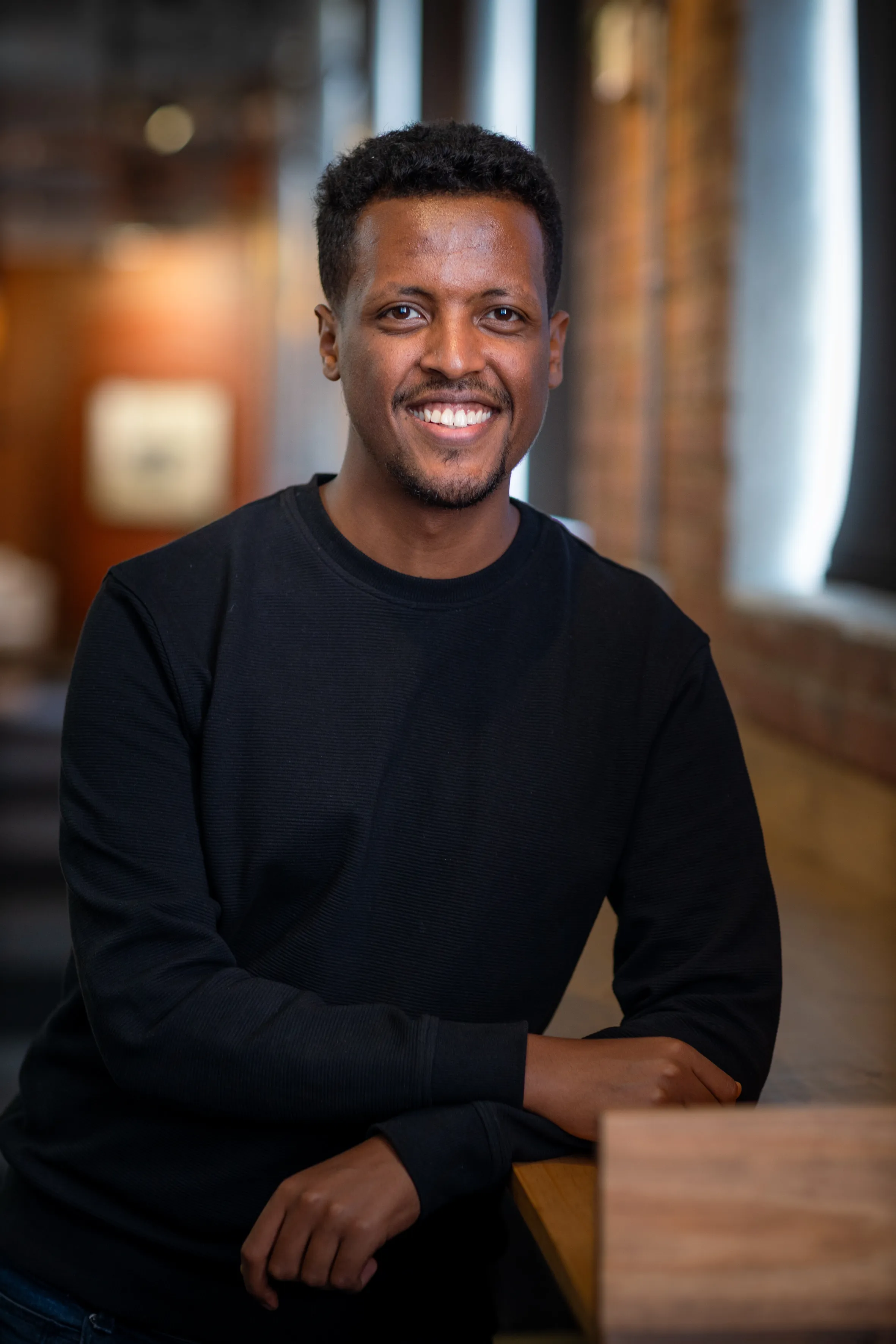 Nathnael sitting on a high desk
